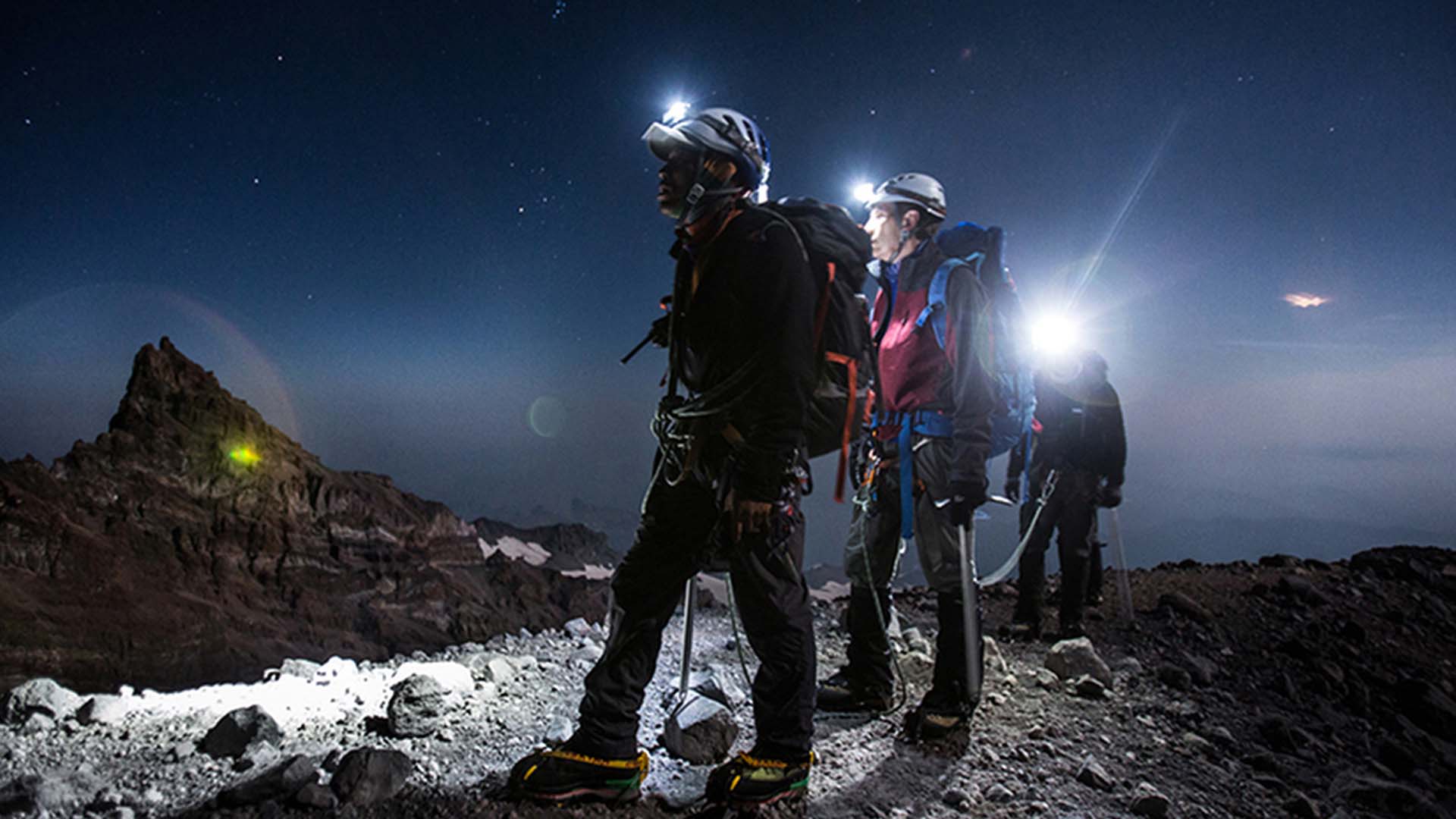 هدلمپ روشن روی کوله‌پشتی در غروب آفتاب